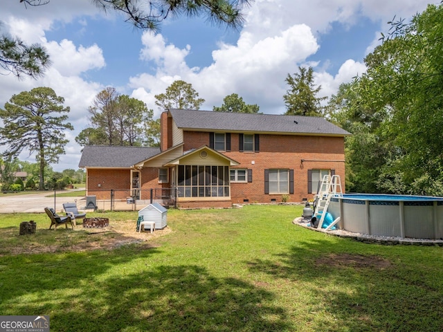 5004 Edith Dr, Albany, GA 31721 - back of property with brick siding, a sunroom, an outdoor pool, and a fire pit