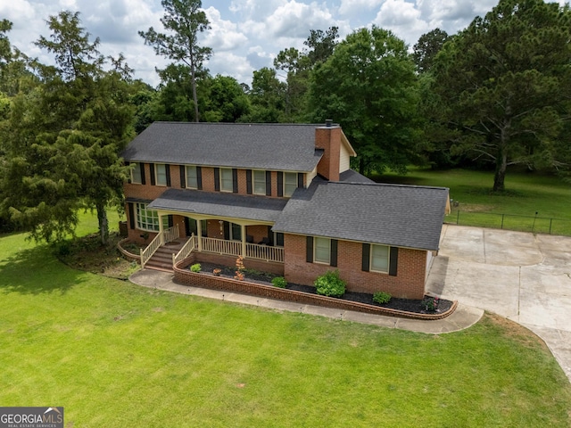 5004 Edith Dr, Albany, GA 31721 - colonial home featuring a porch, a shingled roof, a chimney, brick siding, and concrete driveway