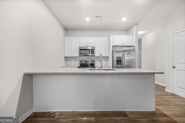 3181 Meadowstone Ln SW, Atlanta, GA 30331 - kitchen featuring appliances with stainless steel finishes, a sink, white cabinets, light stone countertops, and recessed lighting