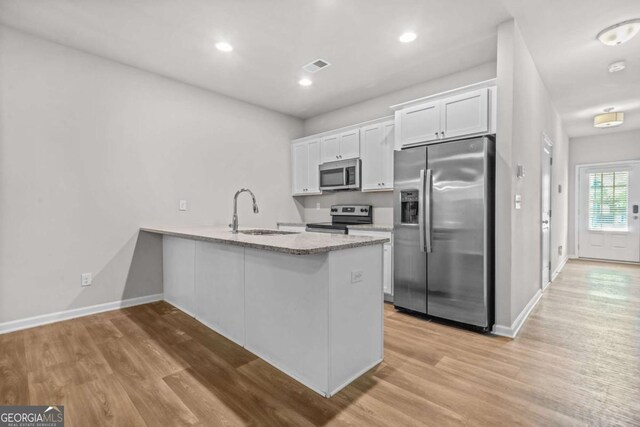 3181 Meadowstone Ln SW, Atlanta, GA 30331 - kitchen with stainless steel appliances, a sink, light wood-style floors, white cabinetry, and recessed lighting