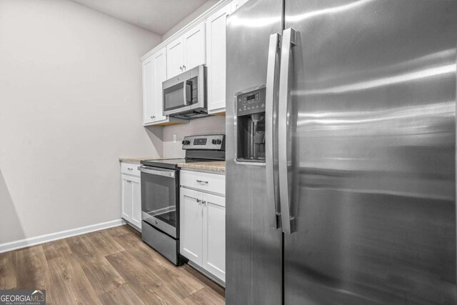 3181 Meadowstone Ln SW, Atlanta, GA 30331 - kitchen with appliances with stainless steel finishes, dark wood-type flooring, white cabinets, and baseboards