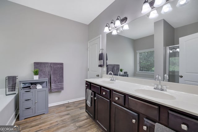 4251 Haywater Cv, Buford, GA 30519 - bathroom featuring double vanity, wood finished floors, a shower stall, and baseboards
