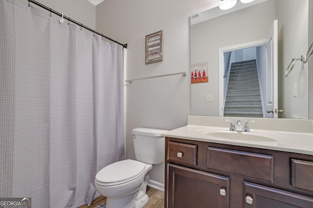 4251 Haywater Cv, Buford, GA 30519 - full bath featuring toilet, vanity, baseboards, wood finished floors, and a shower with shower curtain