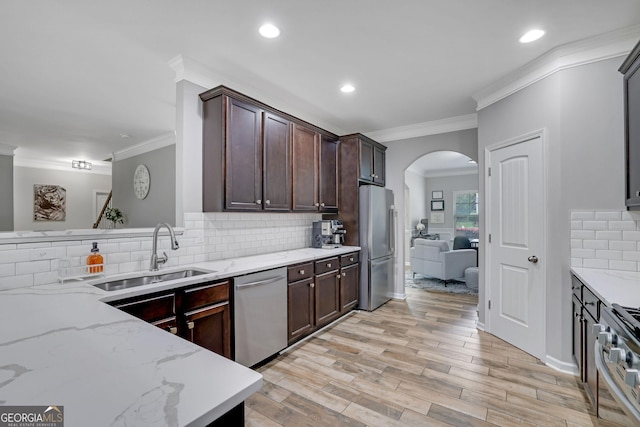 4251 Haywater Cv, Buford, GA 30519 - kitchen featuring a sink, stainless steel appliances, arched walkways, ornamental molding, and tasteful backsplash