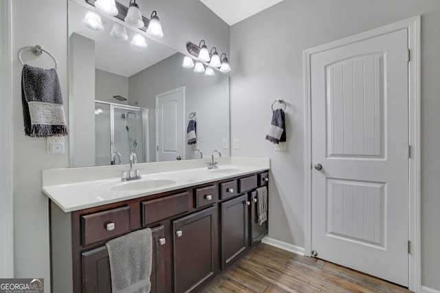4251 Haywater Cv, Buford, GA 30519 - full bathroom with a stall shower, double vanity, wood finished floors, and baseboards