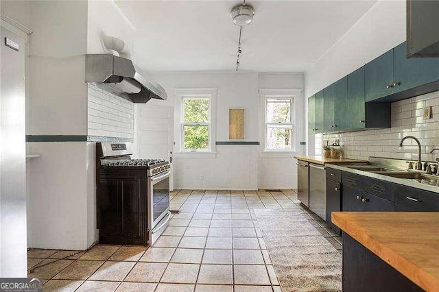 118 Waverly Way, Atlanta, GA 30307 - kitchen with stainless steel appliances, wall chimney exhaust hood, tasteful backsplash, light tile patterned floors, and butcher block countertops