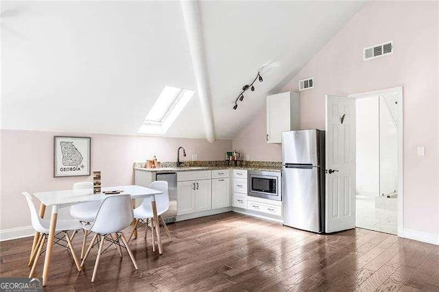 118 Waverly Way, Atlanta, GA 30307 - kitchen with appliances with stainless steel finishes, lofted ceiling, a skylight, wood finished floors, and baseboards