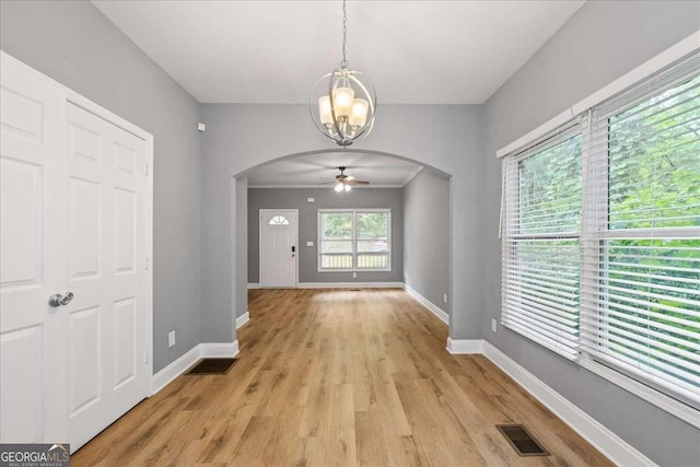 3111 Jones St, East Point, GA 30344 - unfurnished dining area with arched walkways, a chandelier, baseboards, light wood-style floors, and a ceiling fan