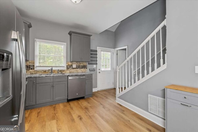 3111 Jones St, East Point, GA 30344 - kitchen with stainless steel appliances, gray cabinetry, a sink, and light wood-style flooring
