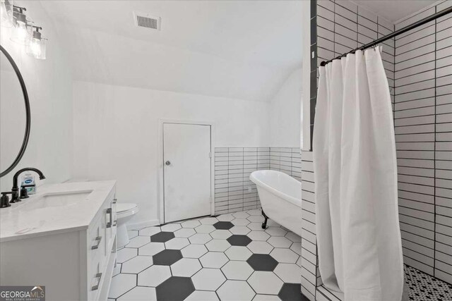 3111 Jones St, East Point, GA 30344 - bathroom featuring tile walls, a freestanding bath, tiled shower, vanity, and tile patterned floors