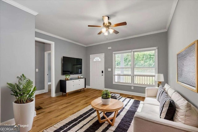3111 Jones St, East Point, GA 30344 - living room with ceiling fan, light wood-style flooring, baseboards, and ornamental molding