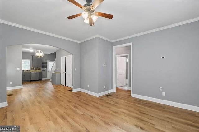 3111 Jones St, East Point, GA 30344 - unfurnished living room with arched walkways, crown molding, ceiling fan, baseboards, and light wood-style floors