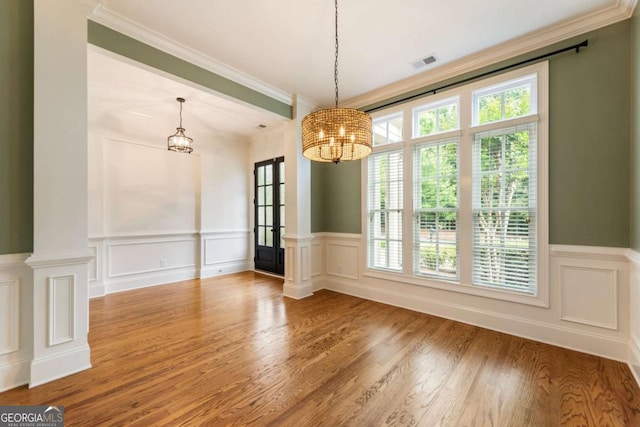 2165 Mcfarlin Ln, Alpharetta, GA 30004 - unfurnished dining area featuring a chandelier, ornate columns, ornamental molding, wood finished floors, and a decorative wall