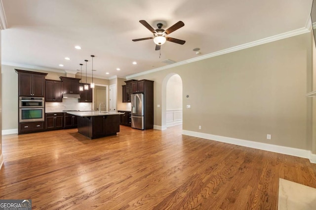 2165 Mcfarlin Ln, Alpharetta, GA 30004 - kitchen with stainless steel appliances, open floor plan, a sink, dark brown cabinetry, and crown molding