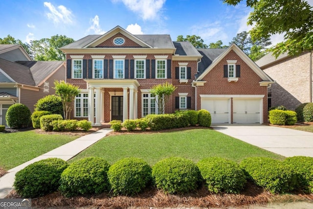 2165 Mcfarlin Ln, Alpharetta, GA 30004 - colonial-style house featuring brick siding, concrete driveway, a front lawn, and a garage
