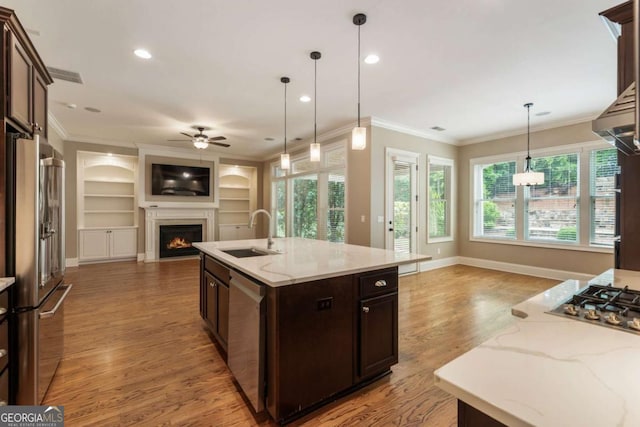 2165 Mcfarlin Ln, Alpharetta, GA 30004 - kitchen with a sink, open floor plan, appliances with stainless steel finishes, ceiling fan, and a warm lit fireplace