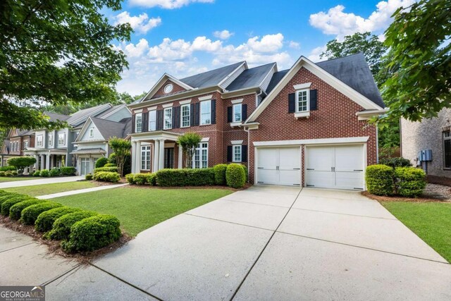 2165 Mcfarlin Ln, Alpharetta, GA 30004 - view of front facade with brick siding, concrete driveway, a front yard, and a garage