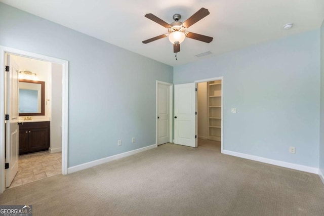 2165 Mcfarlin Ln, Alpharetta, GA 30004 - unfurnished bedroom featuring light carpet, a walk in closet, baseboards, and connected bathroom