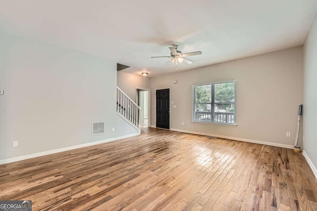 558 Elbridge Dr NW, Atlanta, GA 30318 - unfurnished living room featuring stairs, ceiling fan, and wood finished floors