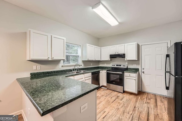 558 Elbridge Dr NW, Atlanta, GA 30318 - kitchen featuring appliances with stainless steel finishes, under cabinet range hood, a peninsula, white cabinetry, and dark countertops