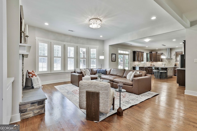 living area with recessed lighting, baseboards, and wood finished floors