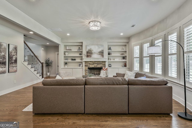 living area with baseboards, a fireplace, recessed lighting, built in shelves, and wood finished floors