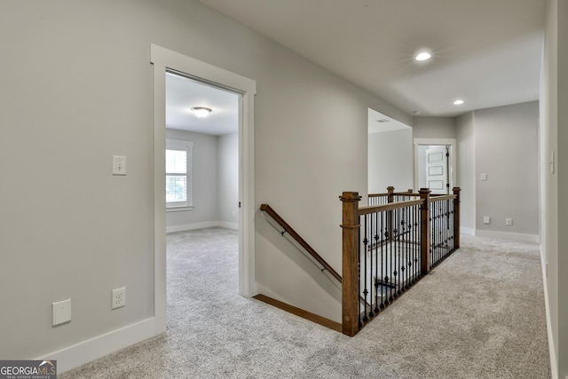 corridor featuring an upstairs landing, carpet flooring, baseboards, and recessed lighting