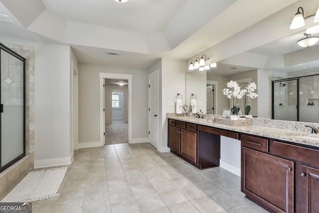 bathroom with a shower stall, tile patterned floors, double vanity, and a raised ceiling