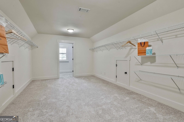 walk in closet featuring carpet floors and vaulted ceiling