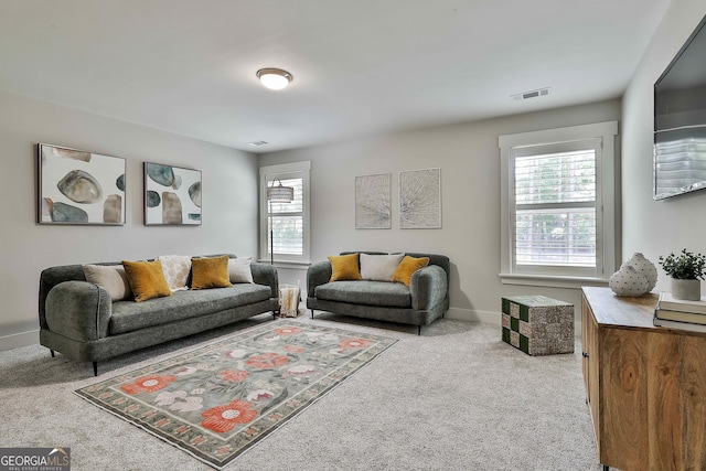 carpeted living area featuring baseboards