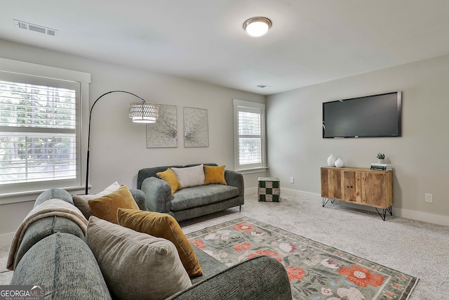 carpeted living area featuring baseboards