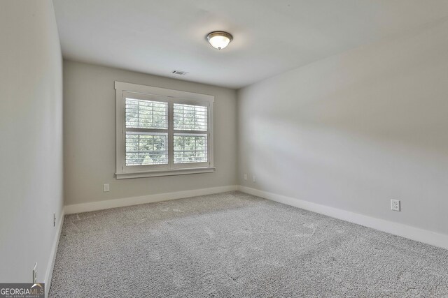 unfurnished room featuring carpet flooring and baseboards