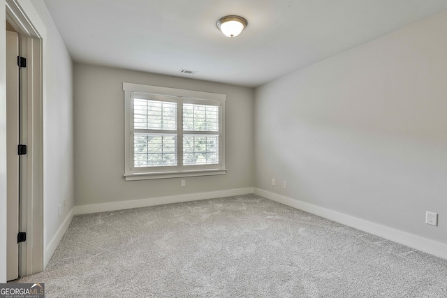 unfurnished room with carpet flooring and baseboards