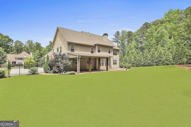 back of property featuring a chimney, fence, and a patio