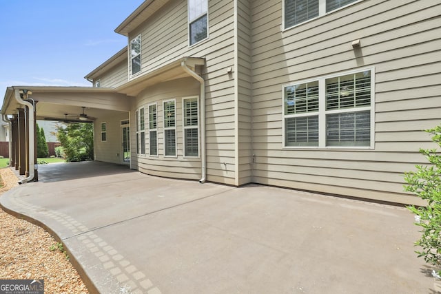 view of patio / terrace with a ceiling fan, driveway, and a carport