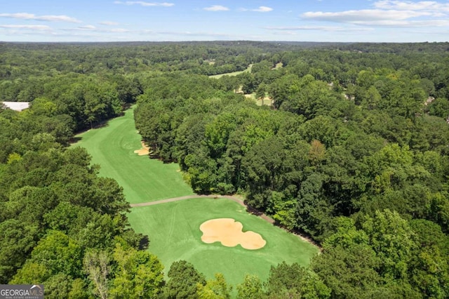 aerial overview of property's location featuring a forest and a golf course