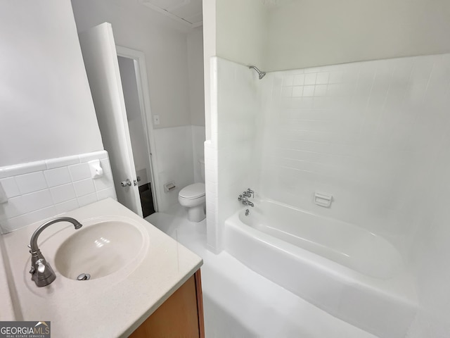 710 Montclair Dr SW, Smyrna, GA 30082 - full bathroom featuring toilet, tile walls, vanity, wainscoting, and shower / tub combination