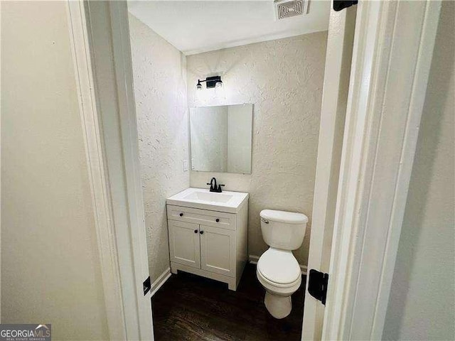 107 Oconnor Dr, Dallas, GA 30157 - half bath with a textured wall, toilet, wood finished floors, and vanity