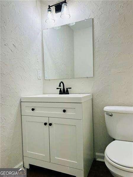 107 Oconnor Dr, Dallas, GA 30157 - half bathroom featuring a textured wall, vanity, toilet, and baseboards