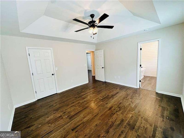 107 Oconnor Dr, Dallas, GA 30157 - unfurnished bedroom featuring a tray ceiling, wood finished floors, baseboards, ensuite bathroom, and a ceiling fan