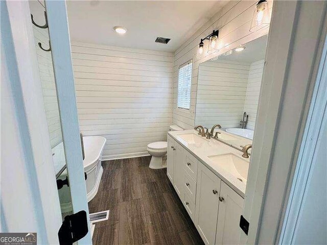 107 Oconnor Dr, Dallas, GA 30157 - bathroom with a soaking tub, wood finished floors, double vanity, and toilet