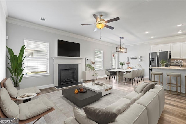 360 Turtle Creek Dr, Winder, GA 30680 - living area featuring plenty of natural light, a ceiling fan, a fireplace, ornamental molding, and light wood-type flooring