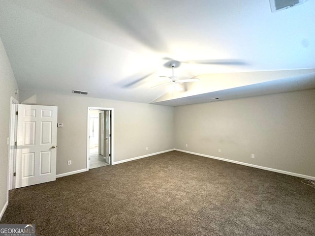 unfurnished bedroom with dark colored carpet, lofted ceiling, baseboards, and a ceiling fan