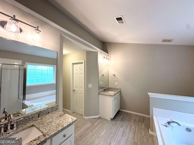 full bath featuring two vanities, a bath, a shower stall, wood finish floors, and baseboards