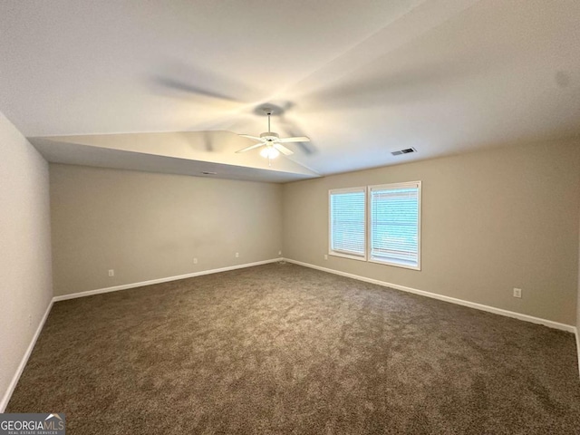 spare room with ceiling fan, dark colored carpet, lofted ceiling, and baseboards