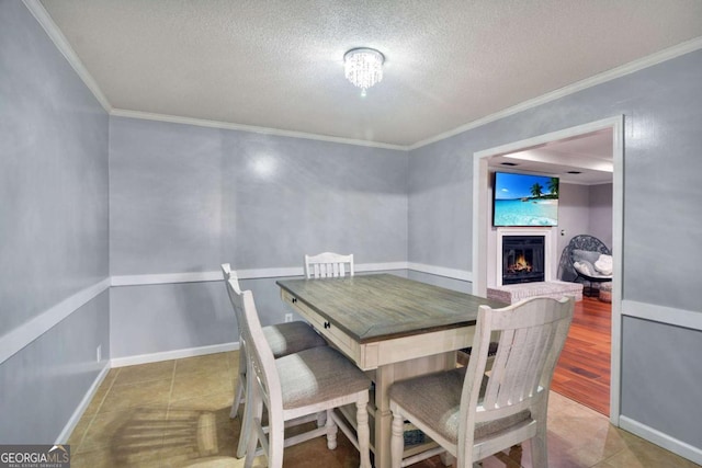 109 Mackqueen Dr, Brunswick, GA 31525 - tiled dining area with a warm lit fireplace, a textured ceiling, ornamental molding, and baseboards
