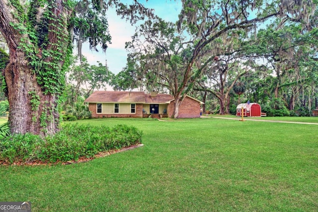 109 Mackqueen Dr, Brunswick, GA 31525 - view of green lawn featuring a storage shed and an outdoor structure