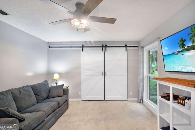 109 Mackqueen Dr, Brunswick, GA 31525 - living area with light carpet, a barn door, a textured ceiling, a ceiling fan, and baseboards