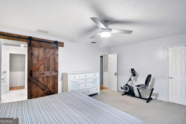 109 Mackqueen Dr, Brunswick, GA 31525 - bedroom with a barn door, light colored carpet, a textured ceiling, and ceiling fan