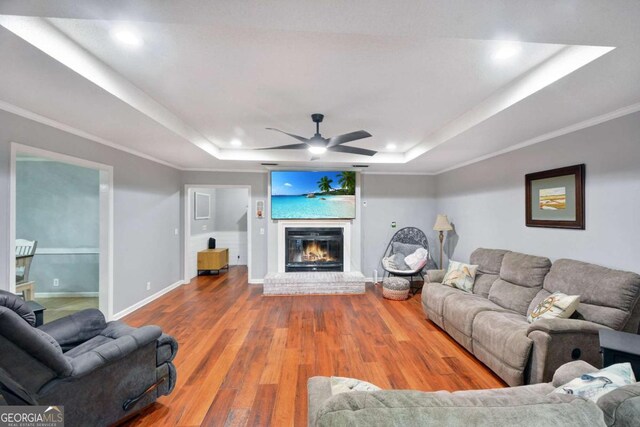 109 Mackqueen Dr, Brunswick, GA 31525 - living room featuring a raised ceiling, wood finished floors, a brick fireplace, baseboards, and recessed lighting